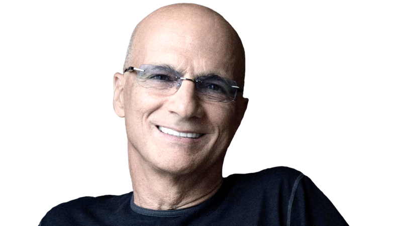 Jimmy Iovine wearing a dark T-shirt and glasses while smiling.